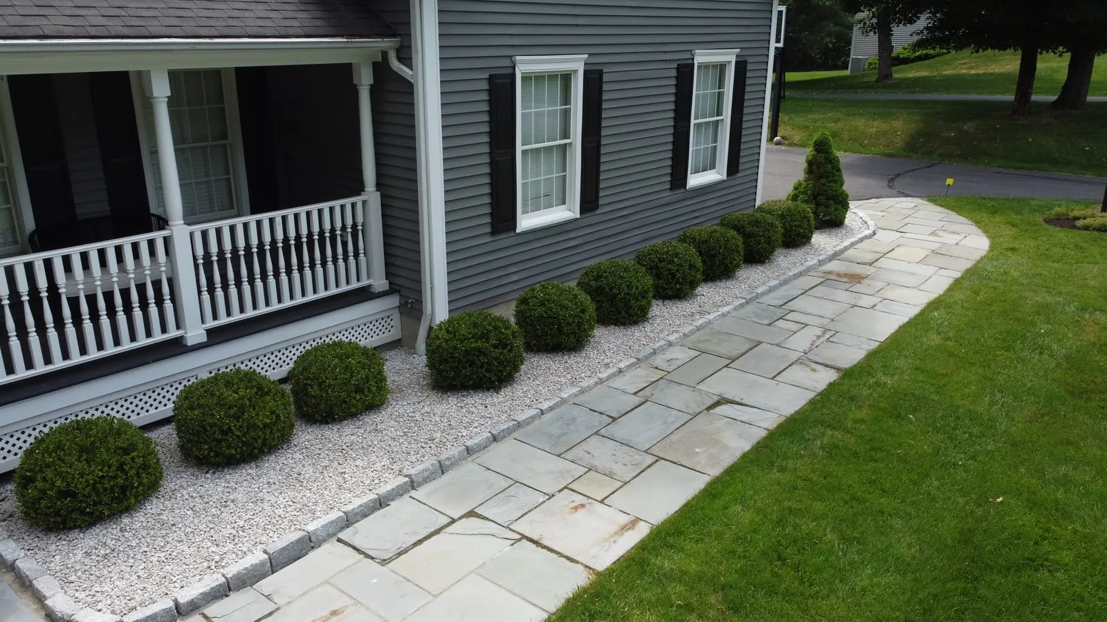 Bluestone walkway with boxwood plantings along a front porch — MRO Landscaping project, Danbury CT
